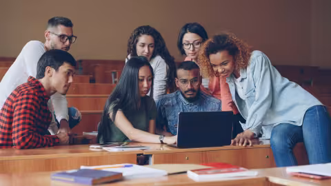 Students sat around a laptop
